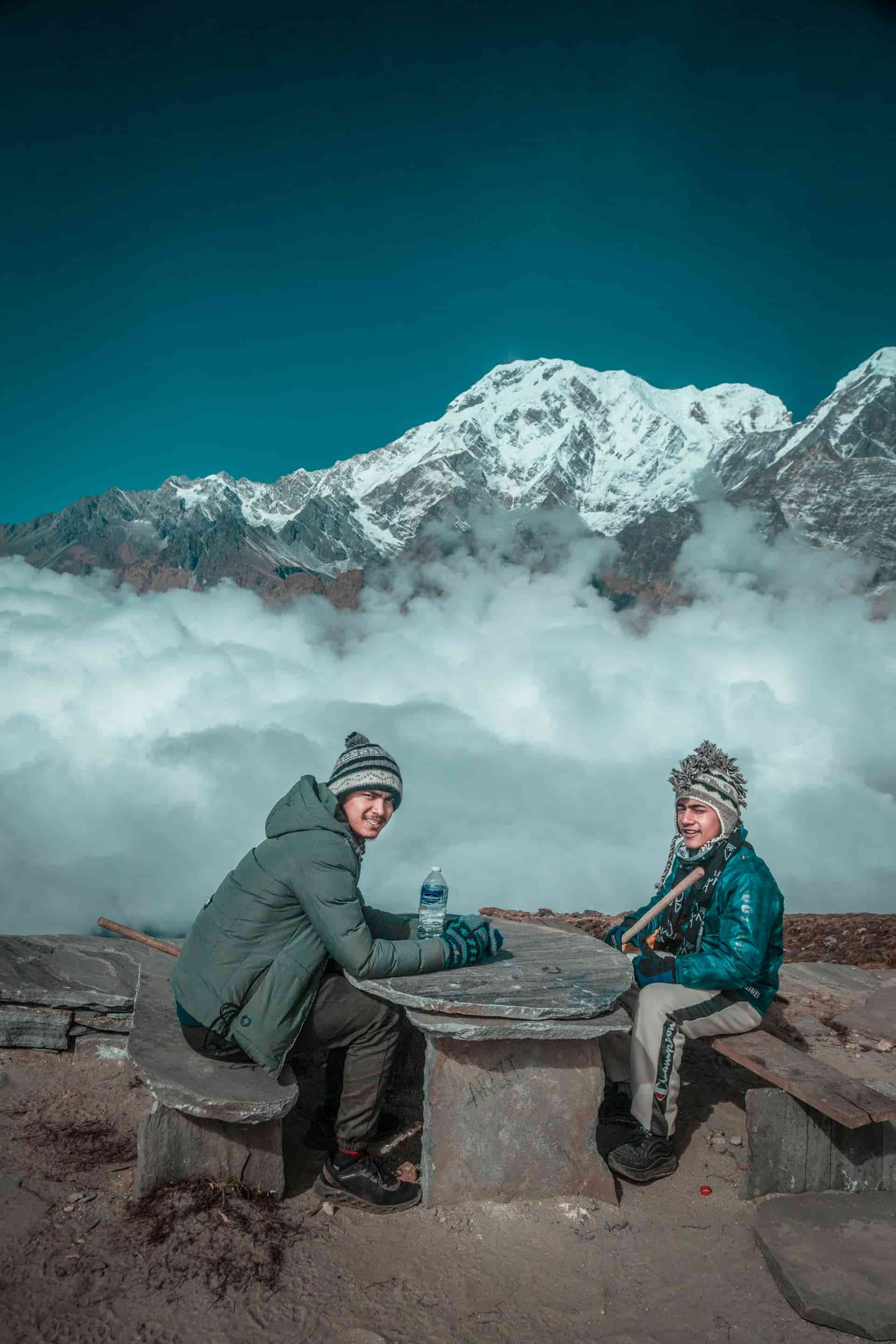 Two Trekkers Resting and Refreshing with Mountain Spring Water on the Mardi Himal Trail